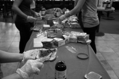 Students prepare peanut butter and jelly sandwiches assembly line style. (Photo Credit: Kelly Pfeister)